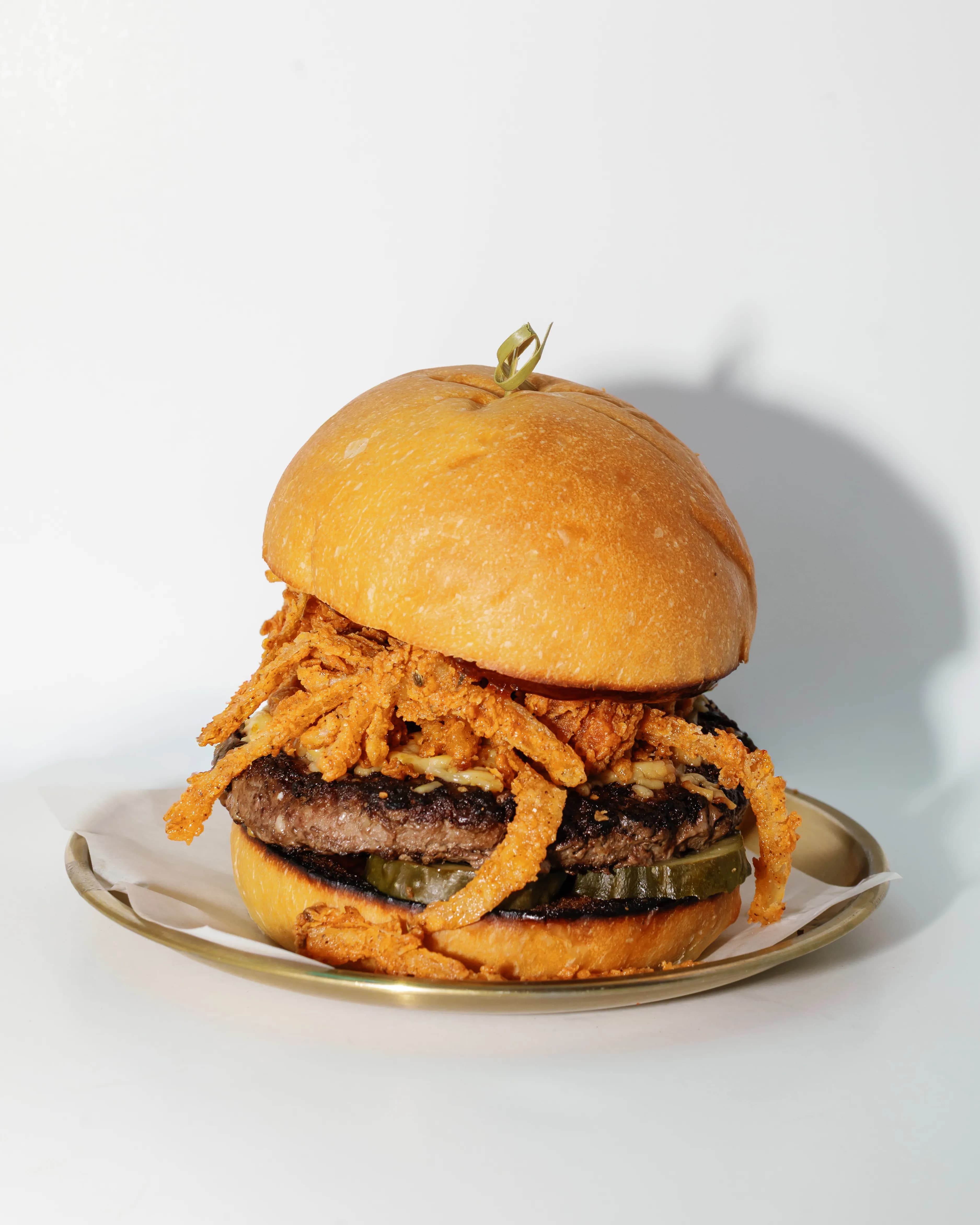 Crispy onion burger with melted cheese on a toasted bun — $7 happy hour bite at Darling Aviary rooftop bar in Downtown Sacramento, Mon–Fri 4–7 PM on K Street